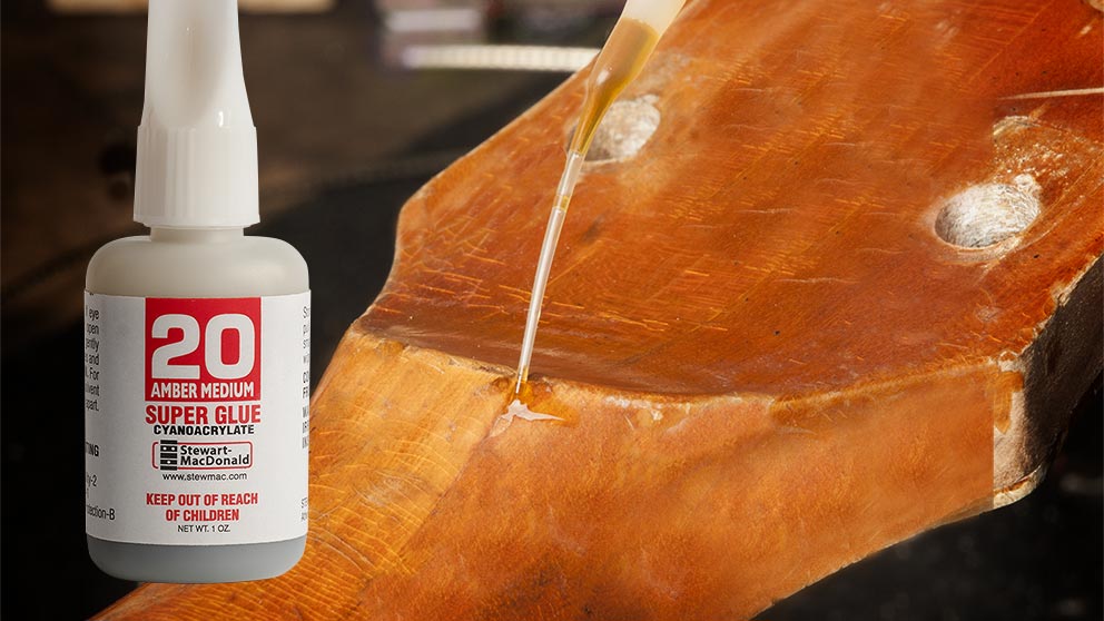Lacquer chip in a vintage guitar neck being filled with amber tinted super glue.