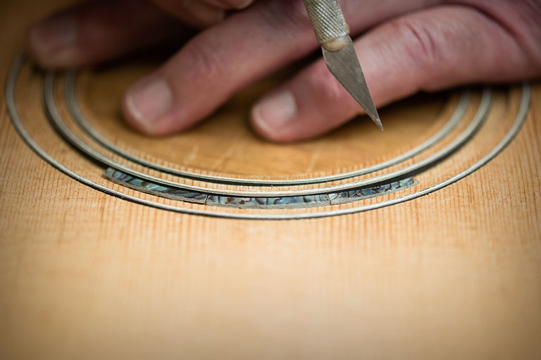 Fitting abalone purfling into a channel for a rosette